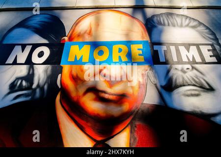 Danzig, Polen. 10. März 2022. Ein Wandgemälde von Putin, Hitler und Stalin mit dem Slogan „No More Time“ ist an der Wand neben dem Bahnhof Danzig-Jasien der PKM zu sehen. Die erste einer Serie von Wandgemälden gegen den Krieg mit dem Titel „Solidarität mit der Ukraine“ wurde erstellt. Der Autor ist Tuse, einer der bekanntesten Straßenkünstler in Polen. Es ist eine gemeinsame Initiative der Woiwodschaft Pommern, der Pommerschen Stadtbahn und der Akademie der Schönen Künste in Danzig. (Foto von Mateusz Slodkowski/SOPA Images/Sipa USA) Quelle: SIPA USA/Alamy Live News Stockfoto