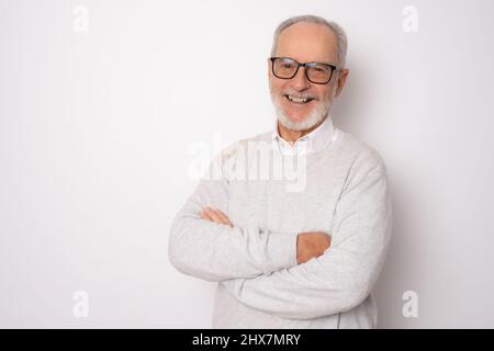 Fröhlicher, fröhlicher Mann in lässiger Kleidung mit gekreuzten Armen und freut sich über seinen Ruhestand. Gesundheit, Beauty-Konzept. Stockfoto