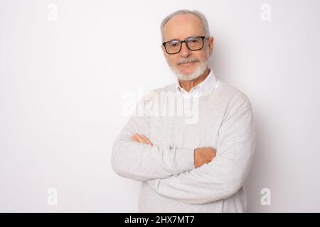 Fröhlicher, fröhlicher Mann in lässiger Kleidung mit gekreuzten Armen und freut sich über seinen Ruhestand. Gesundheit, Beauty-Konzept. Stockfoto