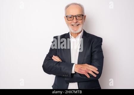 Fröhlicher, fröhlicher Mann in eleganter Kleidung mit gekreuzten Armen und freut sich über seinen Ruhestand. Gesundheit, Beauty-Konzept. Stockfoto