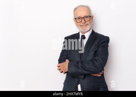 Fröhlicher, fröhlicher Mann in eleganter Kleidung mit gekreuzten Armen und freut sich über seinen Ruhestand. Gesundheit, Beauty-Konzept. Stockfoto