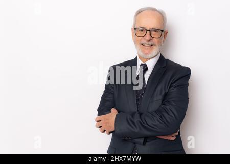 Fröhlicher, fröhlicher Mann in eleganter Kleidung mit gekreuzten Armen und freut sich über seinen Ruhestand. Gesundheit, Beauty-Konzept. Stockfoto