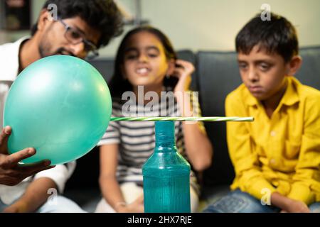 Kinder zu Hause in aufgeregt beobachten satte Klammern oder statische elektrische Wissenschaft Experiment zu Hause, indem sie zeigen Bleistift anzieht, um Ballon - Konzept der Stockfoto