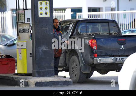Am 9. März 2022 füllt ein Mann den Tank eines Fahrzeugs an einer Agil-Tankstelle in Tunis, Tunesien. Das Ministerium für Industrie, Bergbau und Energie bestätigte am 1. März, dass es die Verkaufspreise für Kraftstoffe an der Pumpe neu einstellen werde, während der Preis für ein Barrel Öl infolge des russischen Krieges in der Ukraine weiter steigt. In der vergangenen Woche schwankte der Preis von Brent zwischen $98 (88 €) und $104 (93 €). Aber diese Erklärung allein bringt nicht die Situation in Tunesien auf den Punkt. Dies ist der zweite Anstieg innerhalb eines Monats, ein äußerst seltenes Ereignis in Tunesien, das den Wunsch der Regierung bestätigt Stockfoto
