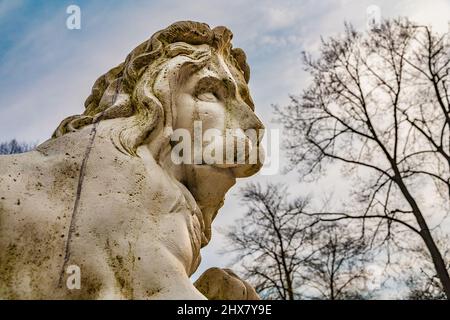 Tolle Nahaufnahme einer weißen, wettergewitterten Löwenstatue im Garten des berühmten Schlosses Schwetzingen in Baden-Württemberg, an einem sonnigen... Stockfoto