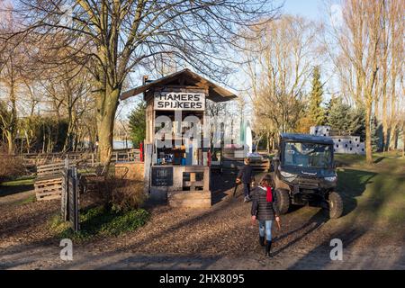 Zwei Kinder bringen ihre Werkzeuge in den Werkzeugschuppen von Fort Plankensteijn auf dem Spielplatz Jeugdland in Amsterdam, Niederlande, zurück. Stockfoto