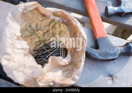 Eine Tüte Nägel und zwei Hämmer, in Fort Plankensteijn auf dem Spielplatz Jeugdland in Amsterdam, Niederlande. Stockfoto