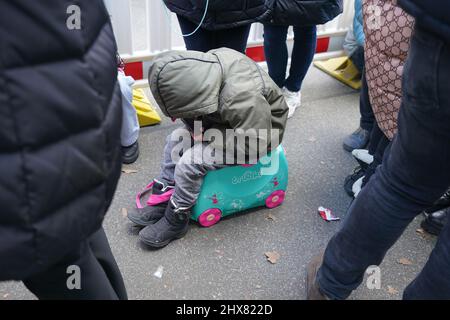 Hamburg, Deutschland. 10. März 2022. Die fünfjährige Sonya aus Kiew spielt auf einem Smartphone in der Warteschlange vor der Zentrale Einwanderungsbehörde mit der neuen Meldestelle im Amt für Migration in der Hammer Straße. Das Mädchen ist mit ihrer Mutter Dasha aus der ukrainischen Hauptstadt nach Deutschland geflohen. Kredit: Marcus Brandt/dpa/Alamy Live Nachrichten Stockfoto