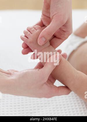 Massieren Sie den Arm Ihres Babys Stockfoto