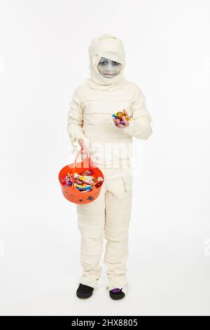 Kind/Model als Mama für Halloween mit einem Trick-or-Treat Eimer gekleidet Stockfoto