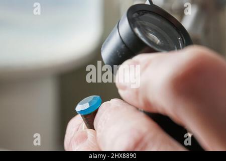 Überprüfen der Facetten eines Edelsteins Stockfoto