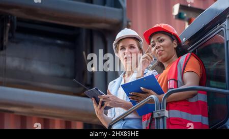 Weibliche Vorarbeiter bleiben auf Heben Container Fracht Gabelstapler prüfen oder überprüfen und kontrollieren Gabelstapler Konzept Service und Transport logistic. Stockfoto