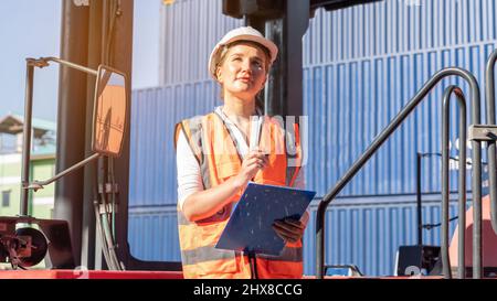 Weibliche Vorarbeiter bleiben auf Heben Container Fracht Gabelstapler prüfen oder überprüfen und kontrollieren Gabelstapler Konzept Service und Transport logistic. Stockfoto