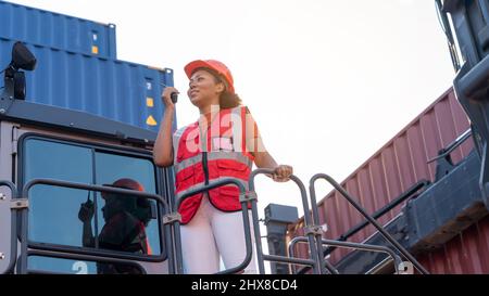 Weibliche Vorarbeiter bleiben auf Heben Container Fracht Gabelstapler prüfen oder überprüfen und kontrollieren Gabelstapler Konzept Service und Transport logistic. Stockfoto