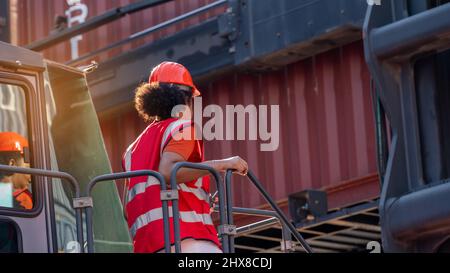 Weibliche Vorarbeiter bleiben auf Heben Container Fracht Gabelstapler prüfen oder überprüfen und kontrollieren Gabelstapler Konzept Service und Transport logistic. Stockfoto