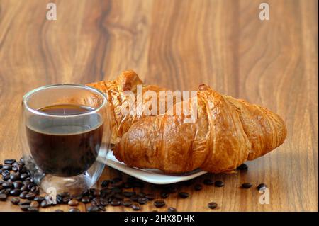 Frisch zubereiteter Espresso zum Frühstück mit knusprigen französischen Croissants Stockfoto