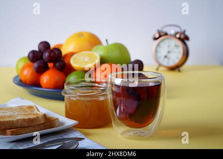 Tee mit geröstetem Toast, Honig und Obst ist ein guter Start in den Tag Stockfoto