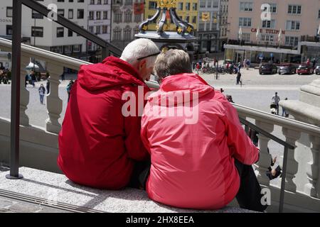 Einsiedeln, Schweiz 05 23 2021 Ältere Paare sitzen auf einer Treppe in der Rückansicht. Stockfoto