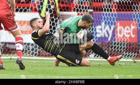 Glenn Morris von Crawley rettet tapfer zu Füßen von Rekeil Pyke von Scunthorpe während des zweiten Spiels der Sky Bet League zwischen Crawley Town und Scunthorpe United im People's Pension Stadium , Crawley , Großbritannien - 5.. März 2022 - nur für redaktionelle Verwendung. Keine Verkaufsförderung. Für Football-Bilder gelten Einschränkungen für FA und Premier League. Keine Nutzung des Internets/Handys ohne FAPL-Lizenz - für Details wenden Sie sich an Football Dataco Stockfoto