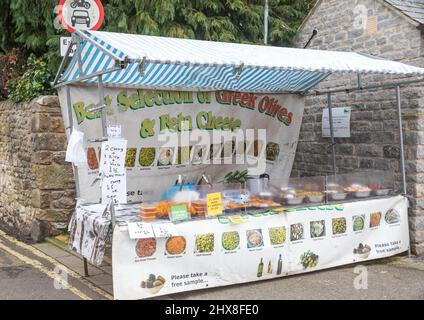 Griechische Oliven und Fetakäse werden am Markttag in Bakewell, Derbyshire, Großbritannien, an einem Marktstand verkauft Stockfoto