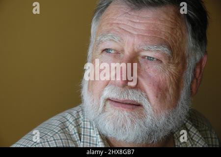 60 Jahre alter weißer Mann mit Bart und kurzen Haaren im Vollgesichtsporträt mit Text- und Textbereich Stockfoto