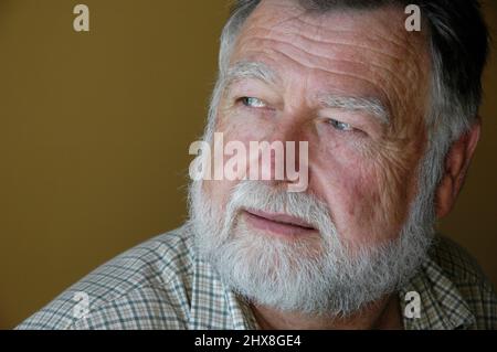 60 Jahre alter weißer Mann mit Bart und kurzen Haaren im Vollgesichtsporträt mit Text- und Textbereich Stockfoto