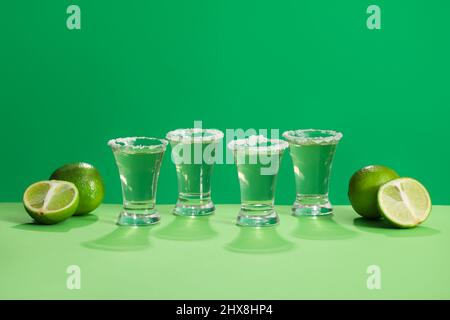 Aufnahmen von leckerem Tequila und Limetten auf farbigem Hintergrund Stockfoto