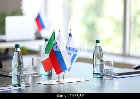 Flaggen von Italien, Israel und Russland auf dem Tisch im Konferenzraum Stockfoto