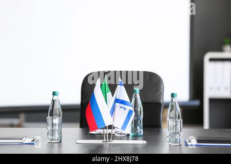 Flaggen von Italien, Israel und Russland auf dem Tisch im Konferenzraum Stockfoto