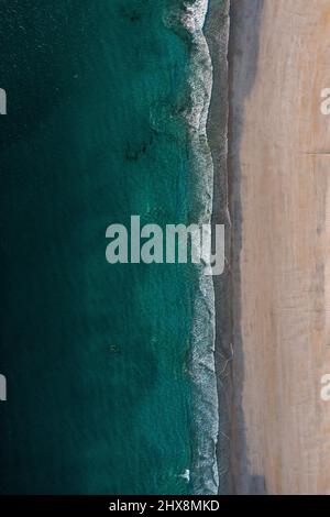 Keine Seele in Sicht, da das aquamarine Wasser gegen diesen perfekten weißen Strand fließt. Stockfoto