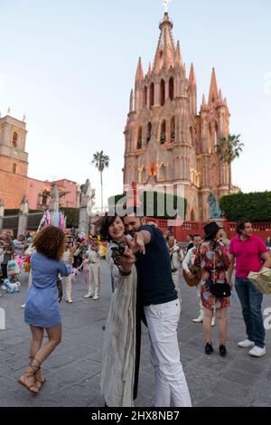 Mexiko, Staat Guanajuato, San Miguel de Allende, Parroquia de San Miguel Arcángel, Paar posiert und hat Spaß vor der Kirche. Stockfoto