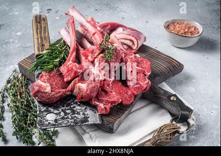 Metzgerschneidebrett mit geschlachttem Raw Lamb Chop Steak oder Hammelfleisch. Grauer Hintergrund. Draufsicht Stockfoto
