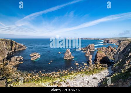 Felsaufschlüsse ragen aus dem strahlend blauen Meer. Stockfoto