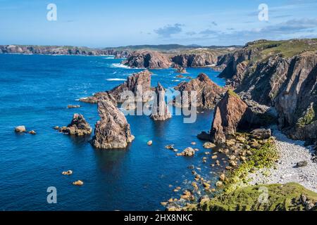 Felsaufschlüsse ragen aus dem strahlend blauen Meer. Stockfoto