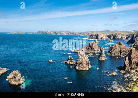 In den Mangersta Sea Stacks erheben sich Felsaufschlüsse aus dem strahlend blauen Meer. Stockfoto