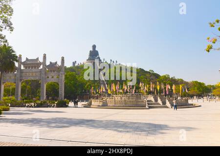 Ngong Ping Piazza Weitwinkel, Insel Lantau, Hongkong, China. Tian Tan Buddha (großer Buddha) im Hintergrund auf einem Hügel und das Tor links Stockfoto