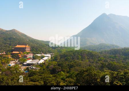 Wunderschöne Aufnahme des Klosters Po Lin und der Berge der Insel Lantau. Luxuriöse Natur rund um den berühmten buddhistischen Tempel. Sonniger, friedlicher Tag Stockfoto