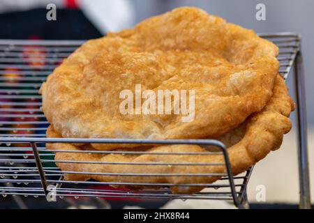 Frisch gebackene Langos werden auf dem Markt angeboten. Ungarische Spezialität, ein frittiertes Fladenbrot aus Kartoffelteig, das auf dem Markt angeboten wird. Stockfoto