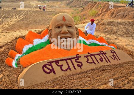 Pushkar, Indien, 10. März 2022: Der Sandkünstler Ajay Rawat entwirft eine Skulptur des Uttar Pradesh-Hauptministers Yogi Adityanath, um ihm zu seinem Sieg bei DEN UMFRAGEN IN DER VERSAMMLUNG zu gratulieren. Die Bharatiya Janata Party (BJP) gewinnt bei den Parlamentswahlen in den Bundesstaaten Uttar Pradesh, Uttarakhand, Goa und Manipur. Kredit: Sumit-Samarwat/Alamy Live Nachrichten Stockfoto