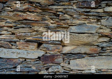 Wandstruktur aus Stein und Ton. Steinhintergrund mit Ton. Stockfoto