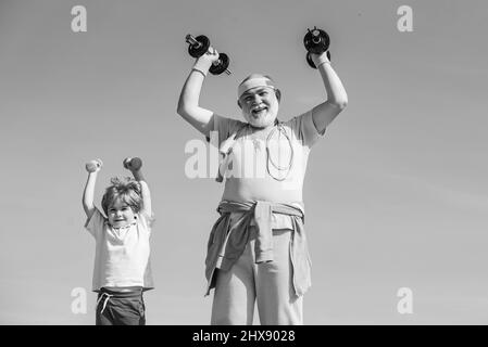 Großvater und Sohn machen Übungen. Vater und Kinder trainieren. Älterer Mann und Kind im Familiengesundheitsclub. Sport für Kinder. Stockfoto