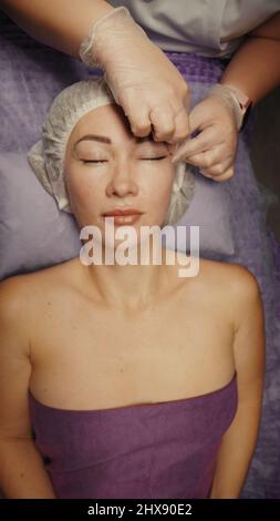 Junge hypnotische Gesichtsfrau erhält Anti-Aging-Gesichtsmassage im Spa-Salon Relax. Wellness Körper Hautpflege Gesicht Schönheitsbehandlung, Verjüngung procedu Stockfoto