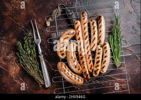 Auswahl an verschiedenen bbq gegrillten Würstchen mit Rind, Schwein, Lamm und Hühnerfleisch auf einem Grill. Dunkler Hintergrund. Draufsicht Stockfoto