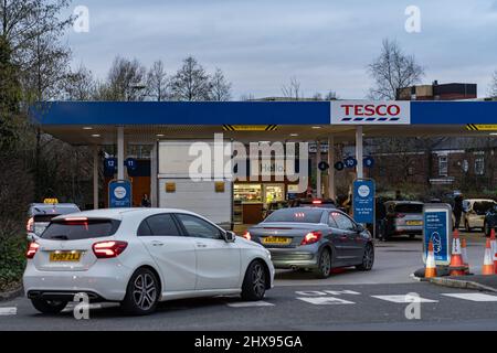 Wigan, Großbritannien: 10. März 2022: An einer Tesco-Tankstelle warten Autos in der Warteschlange, um Kraftstoff zu kaufen, während britische Fahrer in Panik Kraftstoff kaufen Stockfoto