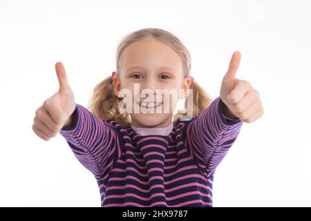 Erfolgreiche junge Mädchen suchen in der Kamera für einen Daumen nach oben. Isolierte Studioaufnahmen mit Kopierplatz. Stockfoto