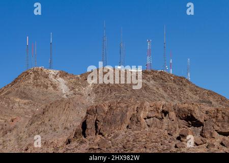 Henderson, NV, USA – 17. Februar 2022: Telekommunikationsradio- und Fernsehantennen-Türme auf einem Berggipfel in Henderson, Nevada. Stockfoto