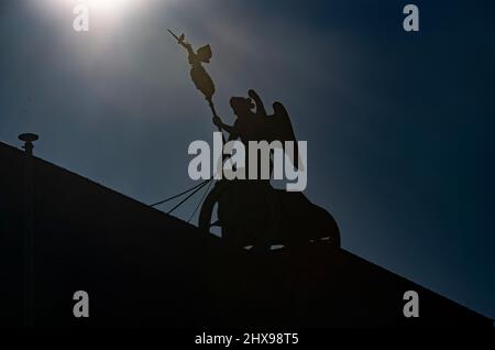 Berlin, Deutschland. 07. März 2022. Im Gegenlicht der Sonne ist die Quadriga am Brandenburger Tor nur als Silhouette zu sehen. Quelle: Paul Zinken/dpa/Alamy Live News Stockfoto