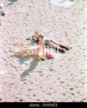 Zwei Frauen sonnen sich am Strand, Blick von oben ca. 1966 Stockfoto