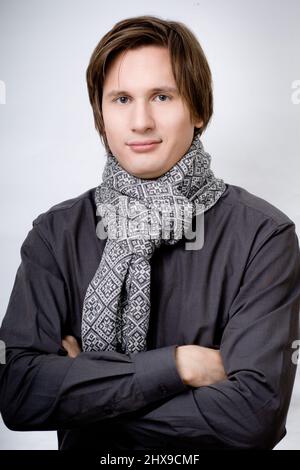Schöner Mann mit gekreuzten Armen im Schal Stockfoto