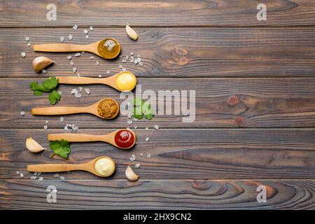 Verschiedene Saucen in Löffeln auf Tischhintergrund, flache Lay Draufsicht. Stockfoto